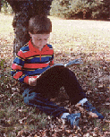 Under a tree reading a book.